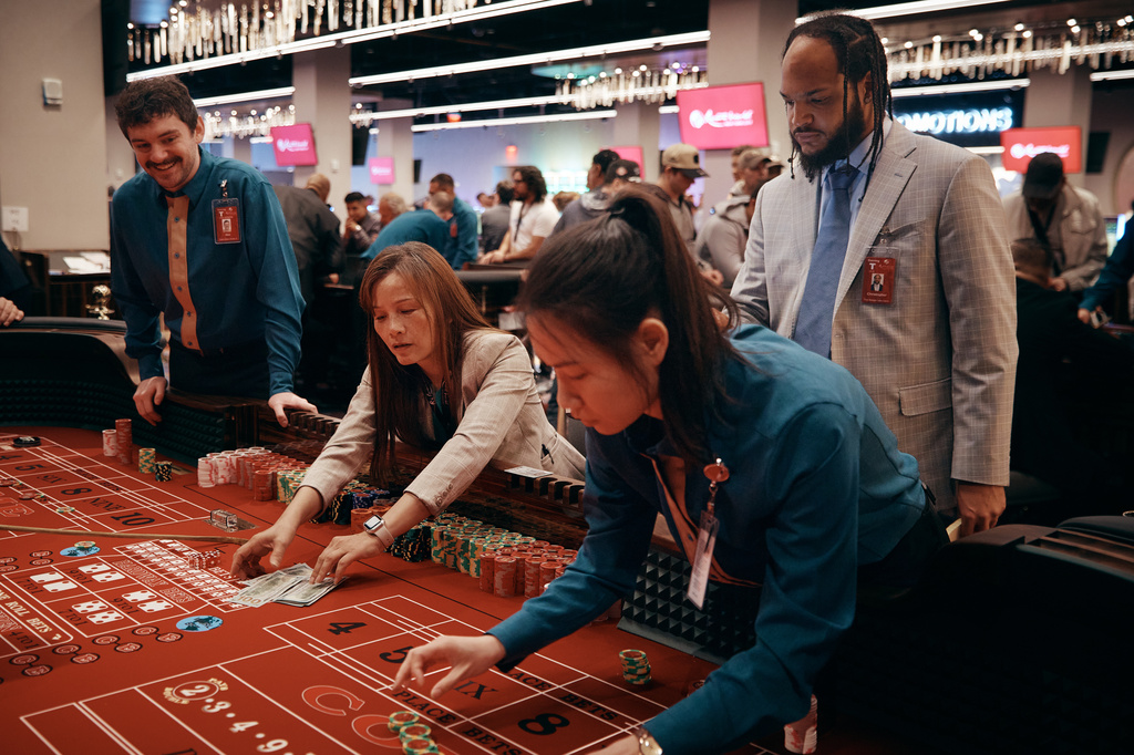 dealer removes cash from a craps table during the opening of a casino floor at Resorts World New York City on Tuesday, April 28, 2026, in New York. (AP Photo/Andres Kudacki)