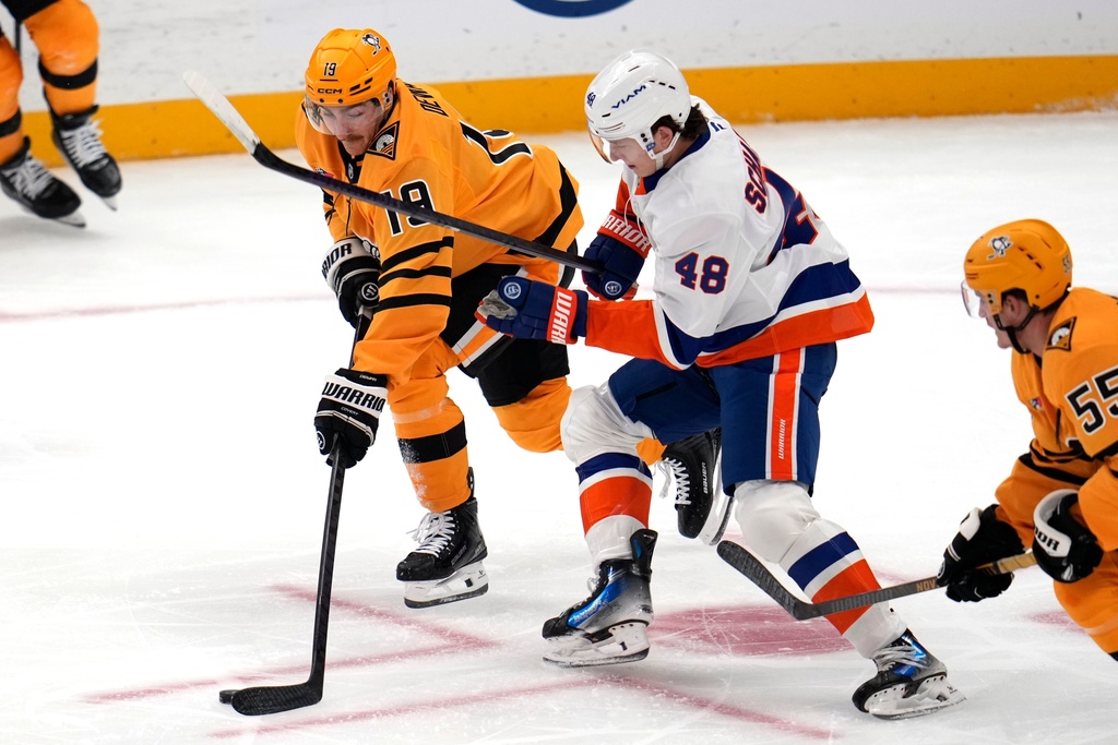 New York Islanders' Matthew Schaefer (48) defends against Pittsburgh Penguins' Connor Dewar (19) during the first period of an NHL hockey game in Pittsburgh, Thursday, Oct. 9, 2025. (AP Photo/Gene J. Puskar)