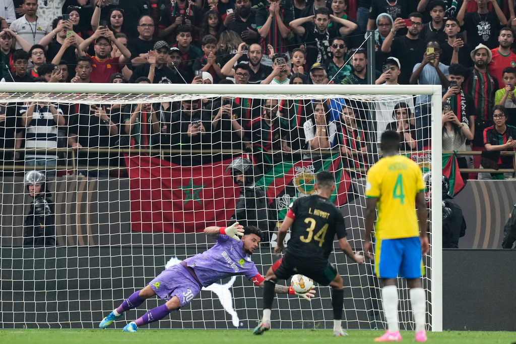 Mamelodi Sundowns' goalkeeper Ronwen Williams, left, dives to safe a penalty kick by AS FAR Rabat's captain Mohamed Rabie Hrimat, center, during the CAF Champions League final soccer match between AS FAR Rabat and Mamelodi Sundowns, in Rabat, Morocco, Sunday, May 24, 2026. (AP Photo/Mosa'ab Elshamy)