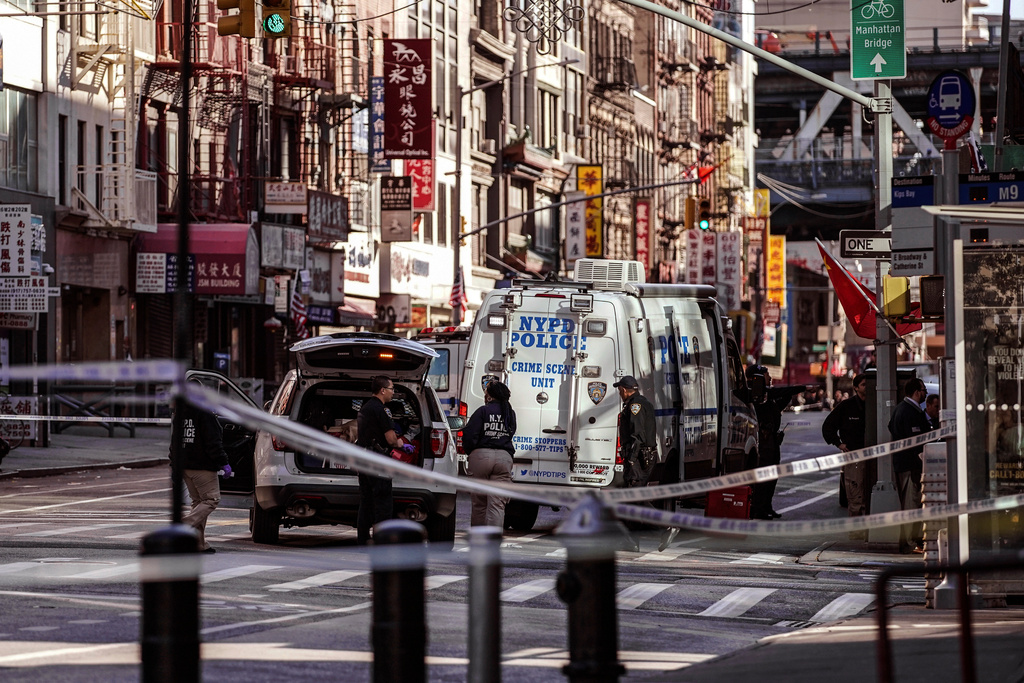 FILE - New York Police Department officers investigate the scene of an attack in Manhattan's Chinatown neighborhood, Oct. 5, 2019, in New York. (AP Photo/Jeenah Moon, File)