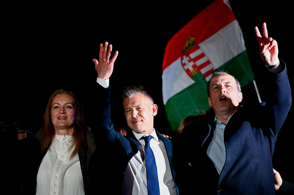 Peter Magyar, leader of the opposition Tisza party, center, celebrates with his party colleagues following the announcement of the partial results of the parliamentary election, in Budapest, Hungary, Sunday, April 12, 2026. (AP Photo/Denes Erdos)