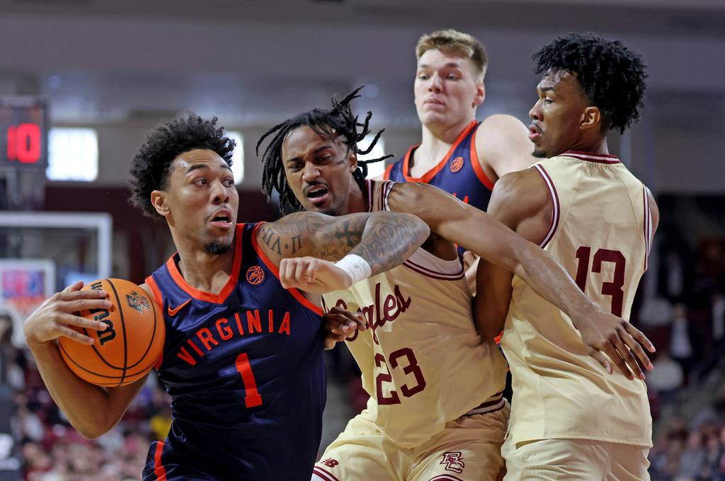 Virginia guard Malik Thomas (1) drives to the hoop against Boston College guard Aidan Shaw (23) and guard Donald Hand Jr. (13) during the first half of an NCAA college basketball game Saturday, Jan. 31, 2026, in Boston. (AP Photo/Mark Stockwell)