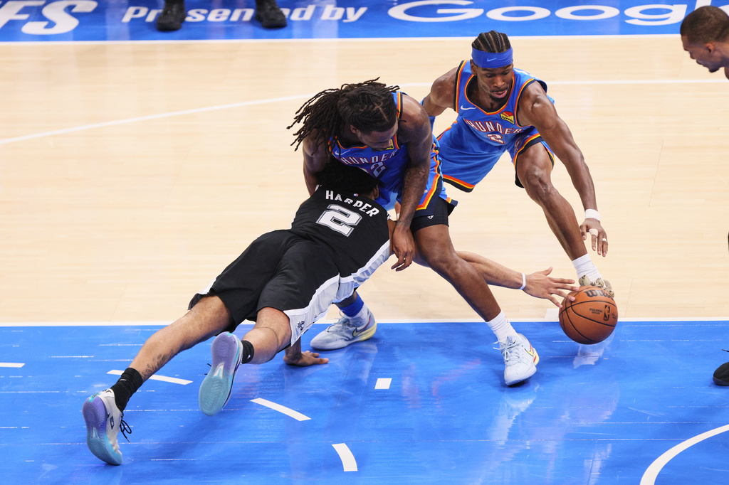 San Antonio Spurs guard Dylan Harper (2) battles for a loose ball against Oklahoma City Thunder guard Cason Wallace (22) and guard Shai Gilgeous-Alexander (2) in the second half of Game 7 of the Western Conference finals of the NBA basketball playoffs series Saturday, May 30, 2026, in Oklahoma City. (AP Photo/Nate Billings)