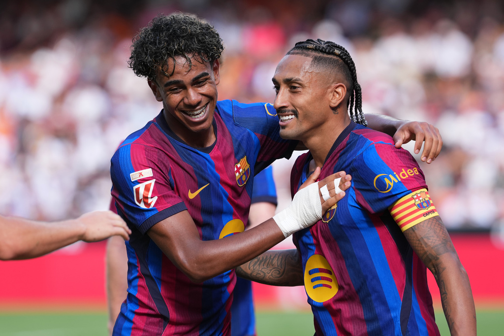 Barcelona's Raphinha, right, celebrates with teammate Lamine Yamal after scoring his side's third goal during the Spanish La Liga soccer match between Valencia and Barcelona in Valencia, Spain, Sunday, Sept. 6, 2026. (AP Photo/Alberto Saiz)
