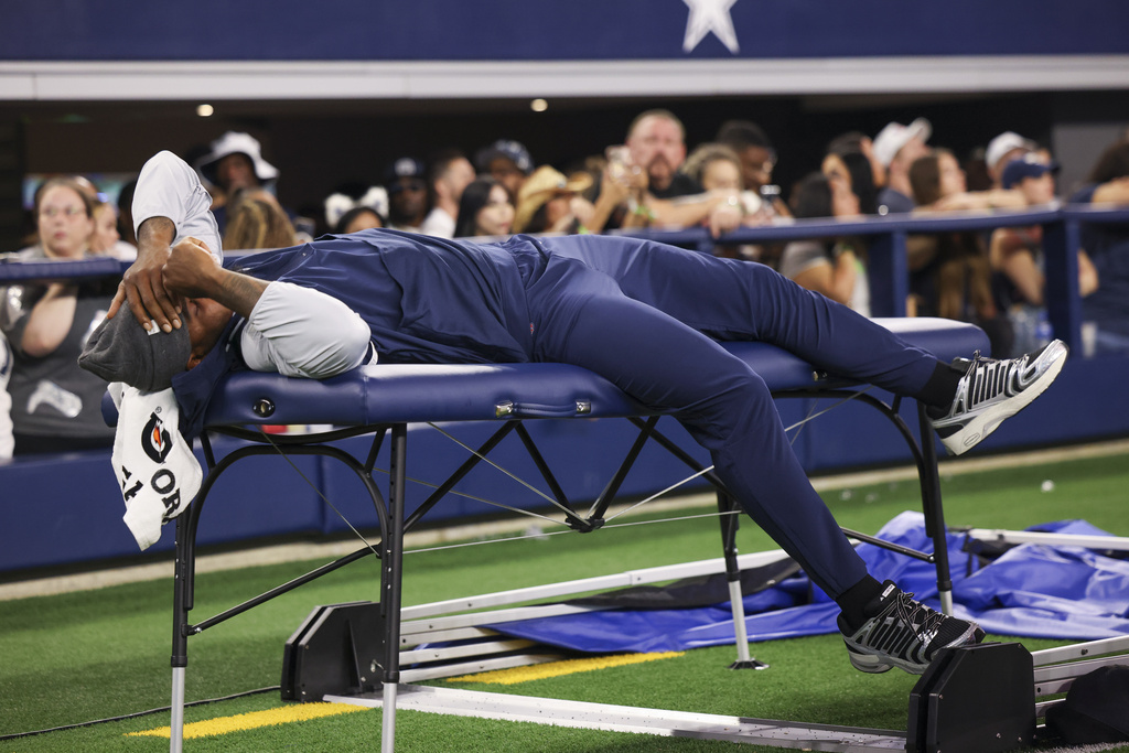 Dallas Cowboys defensive end Micah Parsons lies on the medical table during the second half of a preseason NFL football game against the Atlanta Falcons Friday, Aug. 22, 2025, in Arlington, Texas. (AP Photo/Gareth Patterson)