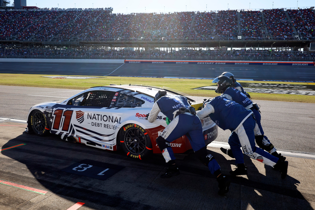 Denny Hamlin's car is pushed to help start it on pit row during a NASCAR Cup Series auto race at Talladega Superspeedway, Sunday, Oct. 19, 2025, in Talladega, Ala. (AP Photo/Butch Dill)