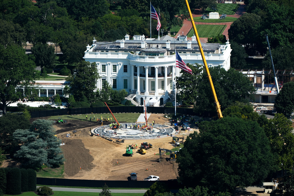 Workers build a helipad on the South Lawn of the White House, left, and continue construction on the new White House ballroom, right, as seen from the Washington Monument, Wednesday, Aug. 19, 2026, in Washington. (AP Photo/Alex Brandon)