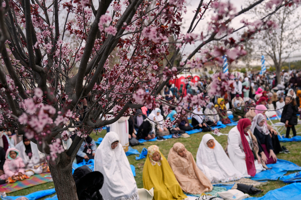 Muslim worshippers pray outside a mosque in Athens during celebrations of Eid al-Fitr, marking the end of the holy fasting month of Ramadan on Friday, March 20, 2026. (AP Photo/Petros Giannakouris)