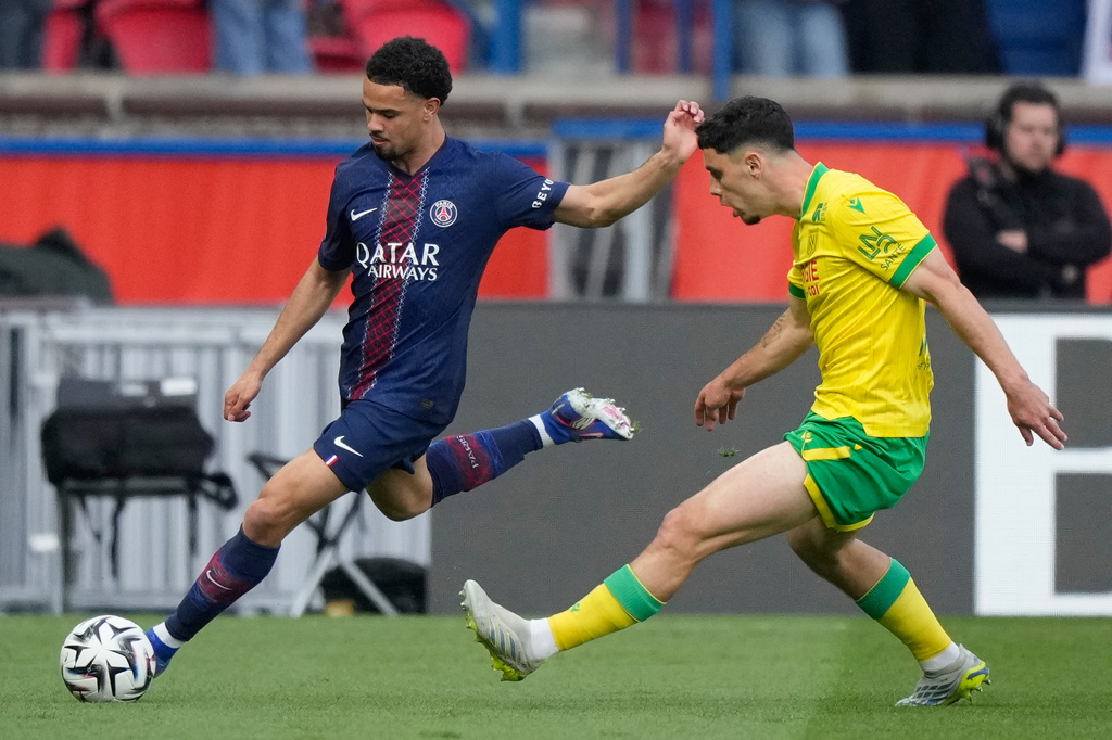 PSG's Warren Zaire-Emery, left, challenge with Nantes' Matthis Abline during the French League One soccer match between Paris Saint-Germain and Nantes in Paris, France, Wednesday, April 22, 2026. (AP Photo/Michel Euler)