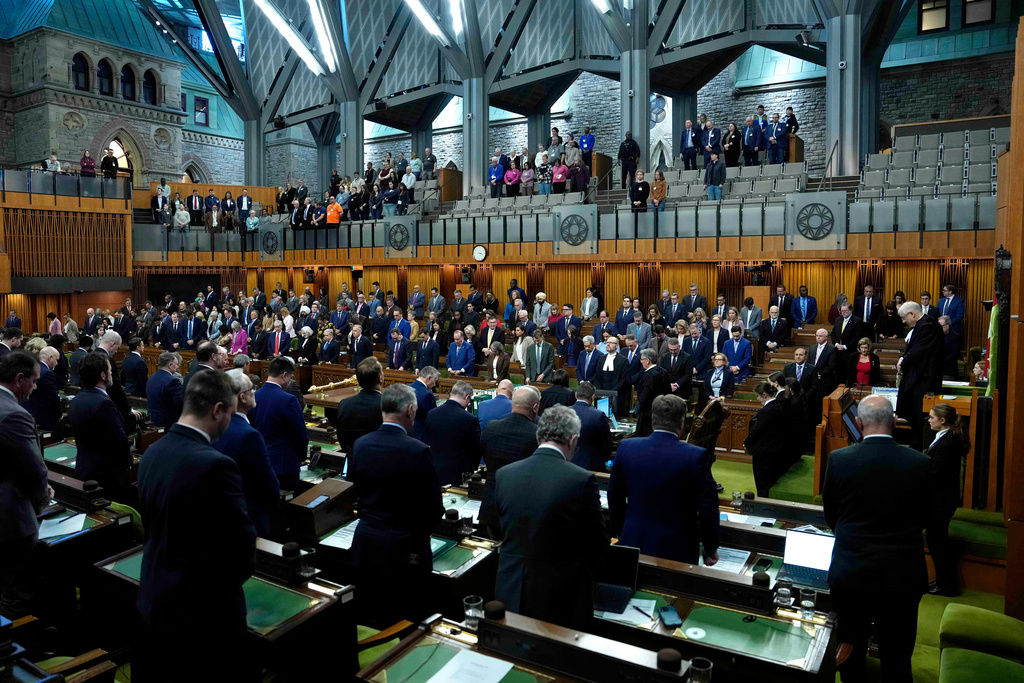 FILE - Members of Parliament rise for a moment of silence in the House of Commons, on Parliament Hill, in Ottawa, Ontario, Feb. 24, 2026. (Justin Tang/The Canadian Press via AP, file)