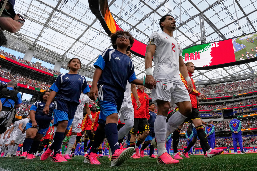 Iran and Belgium players walk out onto the pitch ahead the World Cup Group G soccer match between Belgium and Iran in Inglewood, Calif., near Los Angeles, Sunday, June 21, 2026. (AP Photo/Gregory Bull)