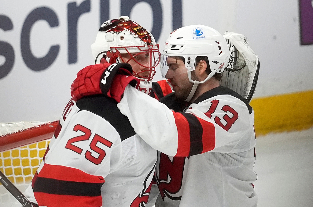 New Jersey Devils goaltender Jacob Markstrom (25) celebrates as time runs out with centre Nico Hischier (13) as the Devils defeat the Ottawa Senators in an NHL hockey game, in Ottawa, Ontario, Tuesday, Dec. 9, 2025. (Adrian Wyld/The Canadian Press via AP)