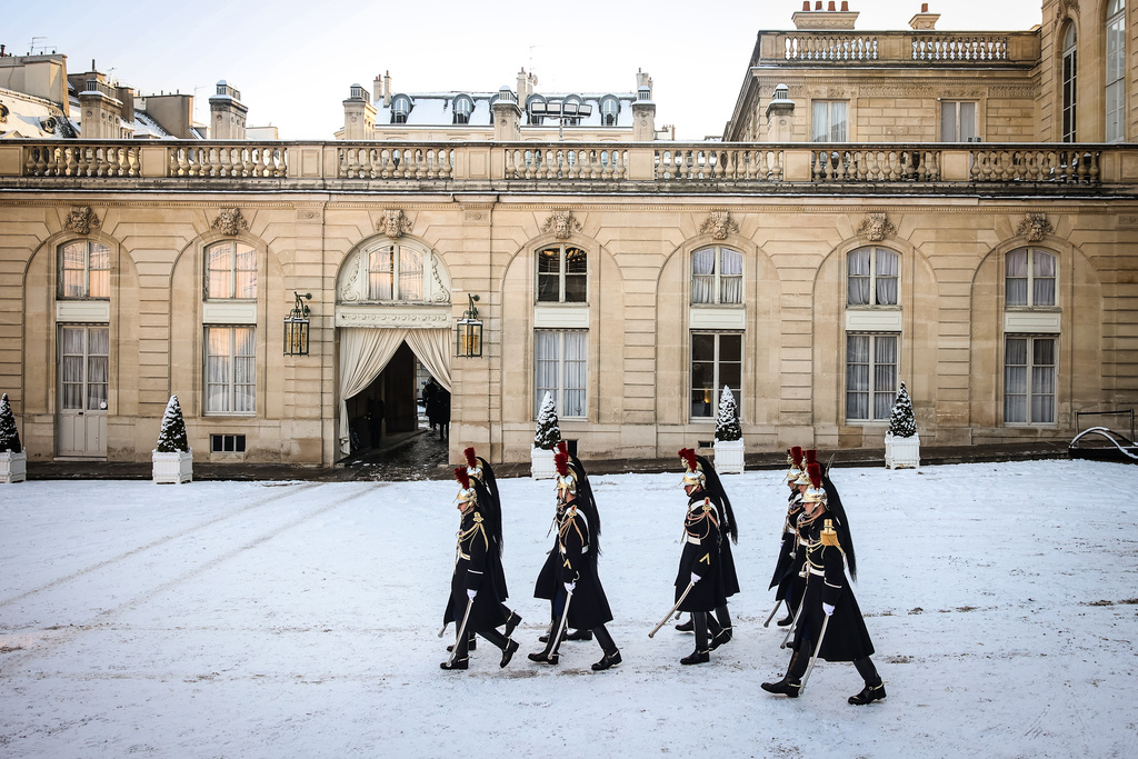 Republican Guards walk in the snow covered courtyard of the Elysee Palace in Paris, France, Tuesday, Jan. 6, 2026. (AP Photo/Thomas Padilla)