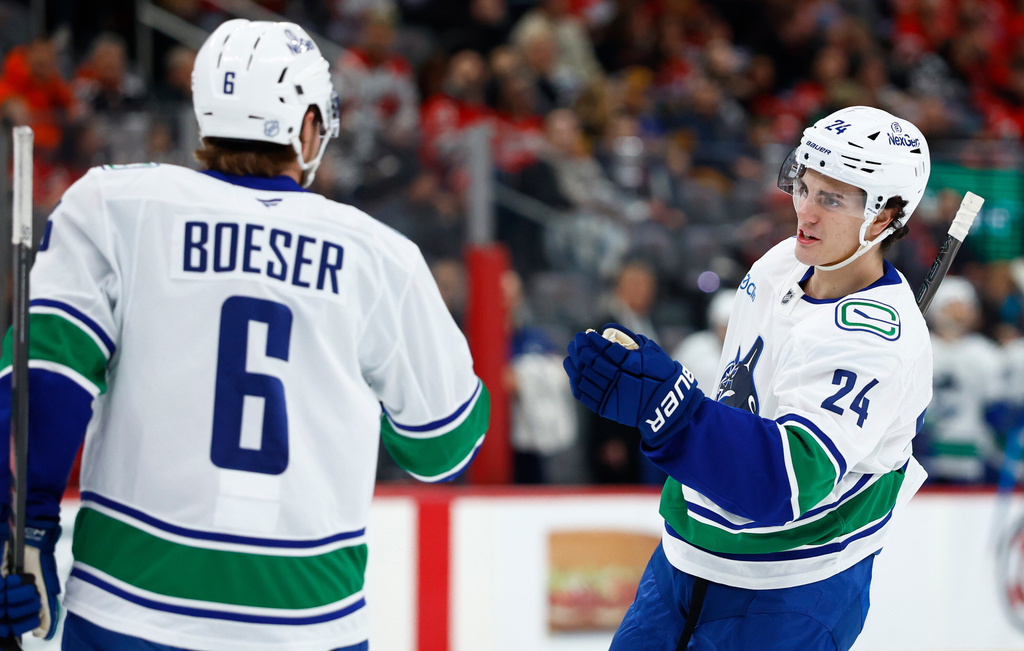 Vancouver Canucks defenseman Zeev Buium (24) celebrates with right wing Brock Boeser (6) after scoring a goal against the New Jersey Devils during the first period of an NHL hockey game, Sunday, Dec 14, 2025, in Newark, N.J. (AP Photo/Noah K. Murray)