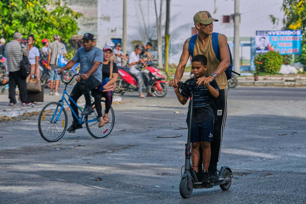 People ride an electric scooter and a bicycle in Havana, Cuba, Friday, May 8, 2026. (AP Photo/Ramon Espinosa)