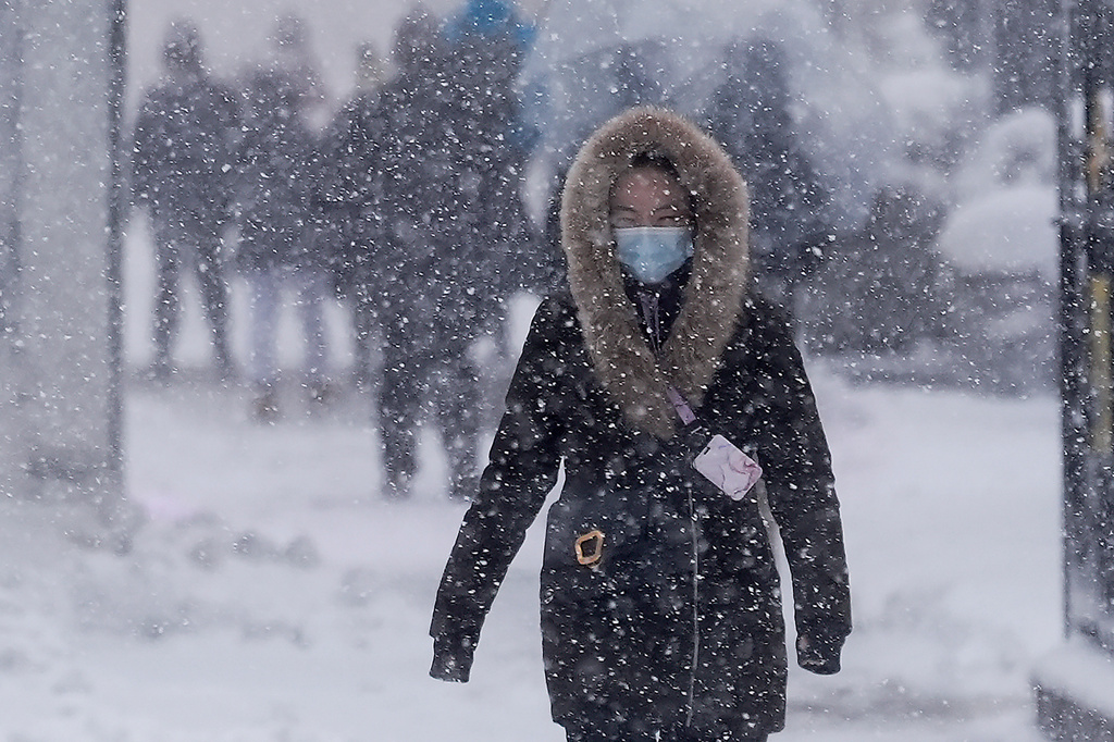 A pedestrian walks along 42nd Street near Bryant Park during a snow storm, Monday, Feb. 23, 2026, in New York. (AP Photo/Seth Wenig)