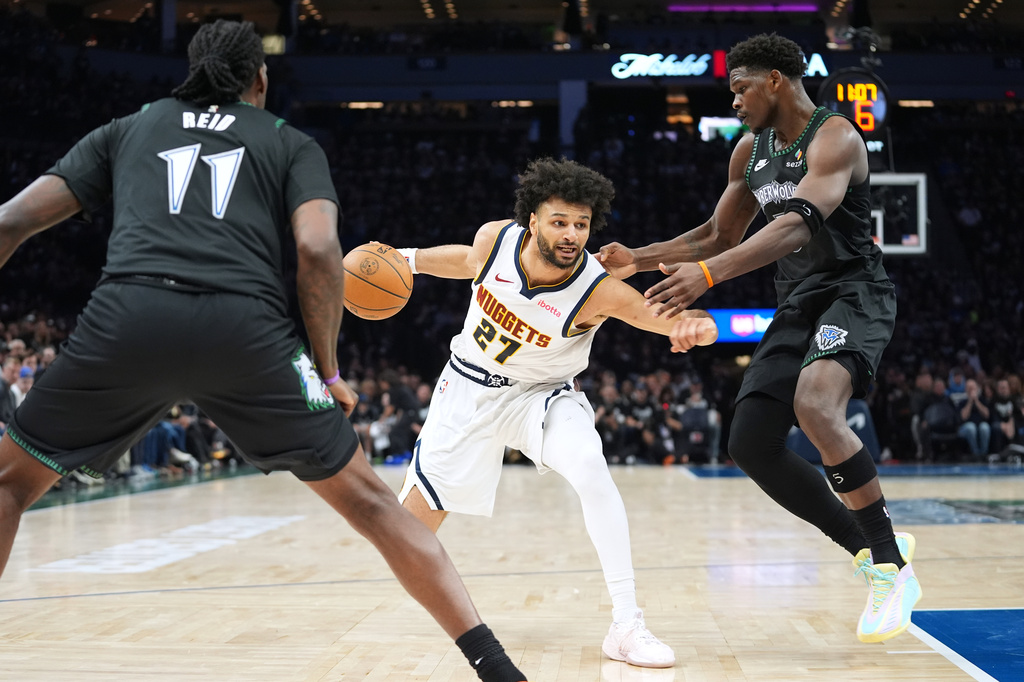 Denver Nuggets guard Jamal Murray (27) works toward the basket as Minnesota Timberwolves center Naz Reid (11) and guard Anthony Edwards (5) defend during the first half in Game 3 of a first-round NBA basketball playoff series, Thursday, April 23, 2026, in Minneapolis. (AP Photo/Abbie Parr)