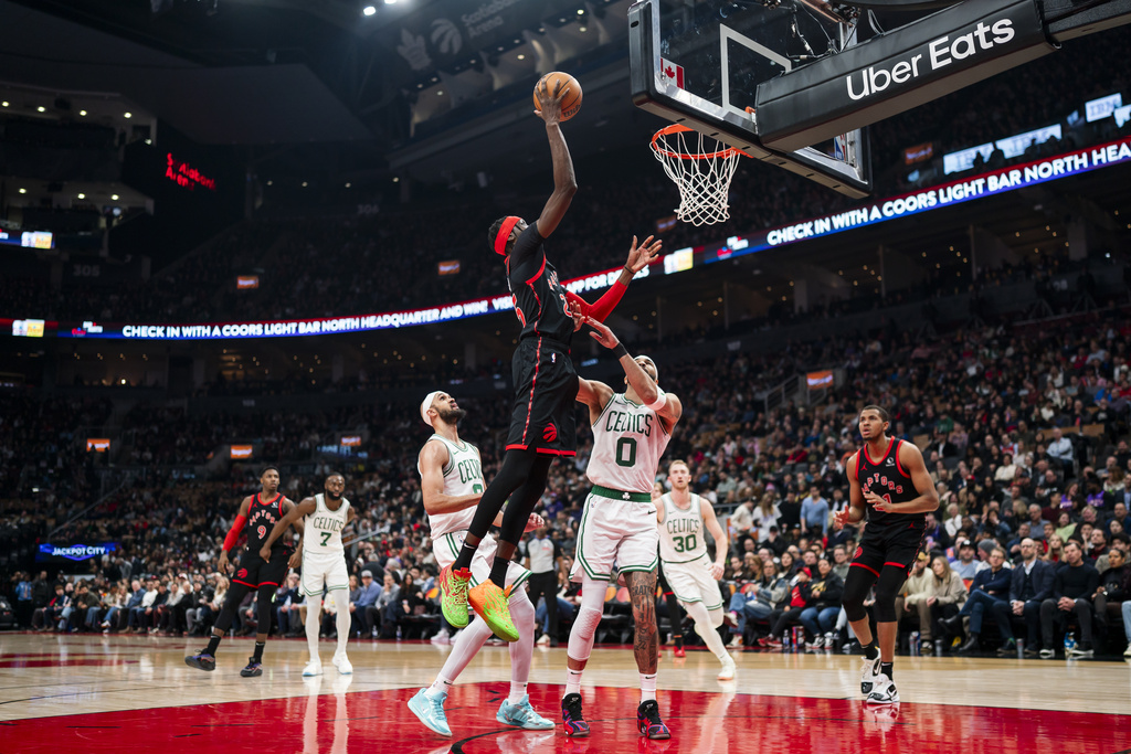 Toronto Raptors forward Chris Boucher (25) drives to the net as Boston Celtics forward Jayson Tatum (0) defends during the first half of NBA basketball action in Toronto on Tuesday, Feb. 25, 2025. (Thomas Skrlj/The Canadian Press via AP)