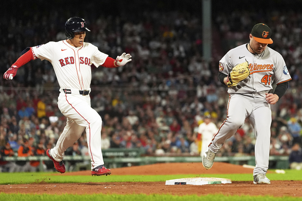 Boston Red Sox's Masataka Yoshida, left, grounds out as Baltimore Orioles pitcher Keegan Akin (45) makes the force in the sixth inning of a baseball game at Fenway Park, Tuesday, Aug. 19, 2025, in Boston. (AP Photo/Charles Krupa)