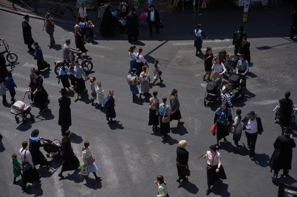 Ultra-Orthodox Jews cross a street in the Mea Shearim neighborhood of Jerusalem, Tuesday, Aug. 18, 2026. (AP Photo/Ohad Zwigenberg)