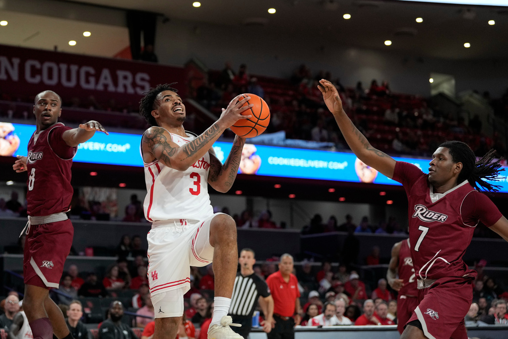 Houston guard Ramon Walker Jr. (3) drives between Rider guard Devean Williams (8) and forward Davis Bynum (7) to score during the second half of an NCAA college basketball game Thursday, Nov. 20, 2025, in Houston. (AP Photo/Kevin M. Cox)