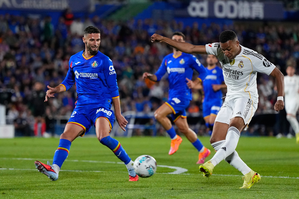 Real Madrid's Kylian Mbappe shoots by Getafe's Domingos Duarte during a La Liga soccer match between Getafe and Real Madrid in Getafe, Spain, Sunday, Oct. 19, 2025. (AP Photo/Manu Fernandez)