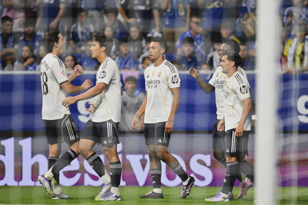 Real Madrid's Vinicius Junior, back right, is congratulated after scoring his side's 3rd goal during a Spanish La Liga soccer match between Real Oviedo and Real Madrid at Carlos Tartiere stadium in Oviedo, Spain, Sunday, Aug. 24, 2025. (AP Photo/Miguel Oses)