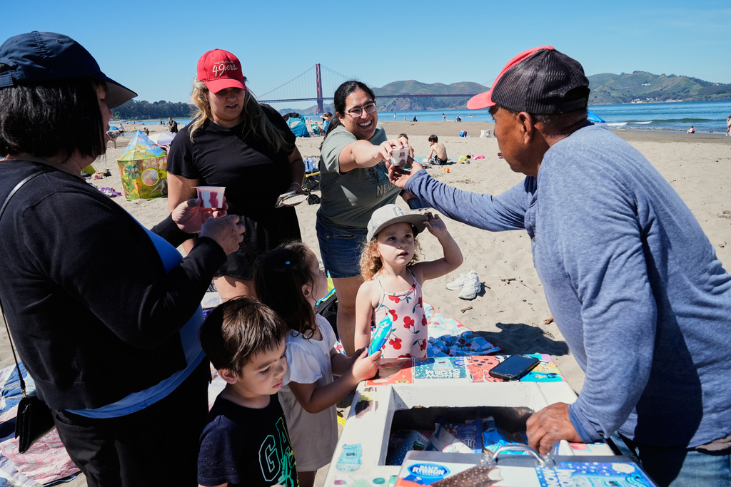 People buy ice cream treats from a paletero at Crissy Field East Beach in San Francisco, Tuesday, March 17, 2026. (AP Photo/Godofredo A. Vásquez)