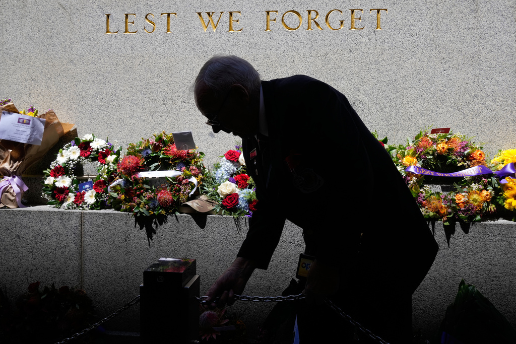Cenotaph attendant and veteran Bob Hall adjusts a chain during Remembrance Day ceremonies to commemorate the armistice of World War I in Sydney, Australia, Tuesday, Nov. 11, 2025. (AP Photo/Rick Rycroft)