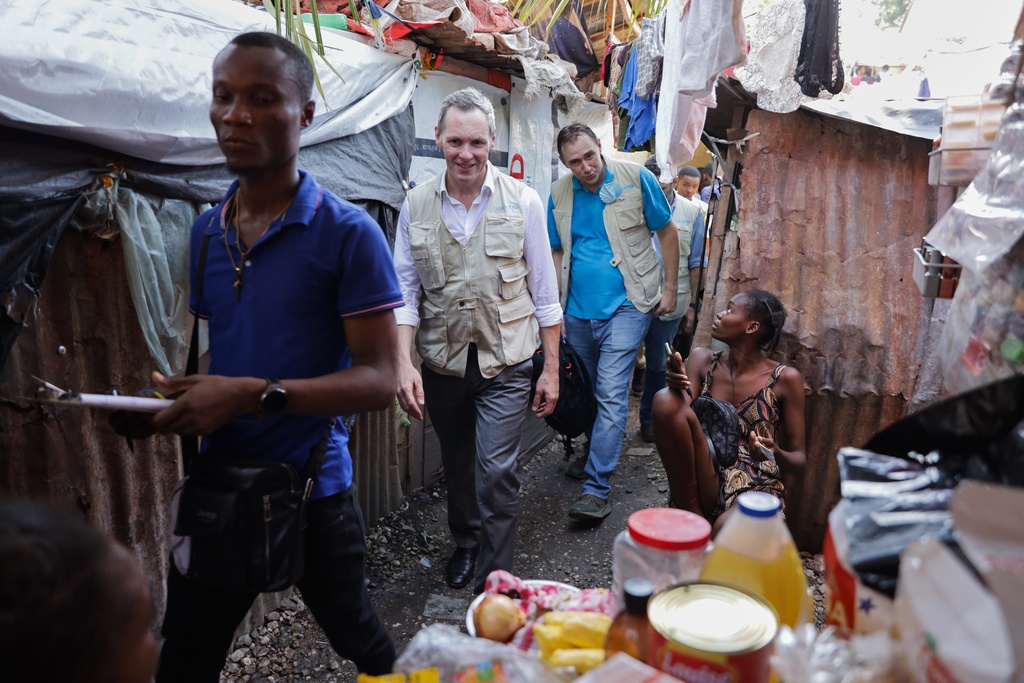 UNICEF Regional Director for Latin America and the Caribbean Roberto Benes, center, visits a shelter for families displaced by gang violence in Port-au-Prince, Haiti, Tuesday, Oct. 7, 2025. (AP Photo/Patrice Noel)