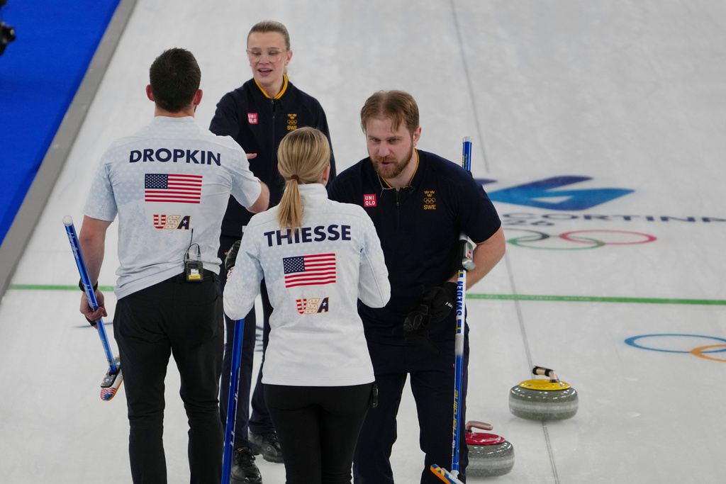 Sweden's Rasmus Wranaa and Isabella Wranaa cheer with United States' Korey Dropkin and Cory Thiesse after winning the gold medal mixed doubles curling match against USA, at the 2026 Winter Olympics, in Cortina D'Ampezzo, Italy, Tuesday, Feb. 10, 2026. (AP Photo/Misper Apawu)