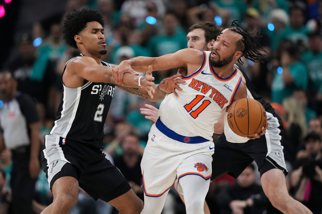 New York Knicks guard Jalen Brunson (11) is pressured by San Antonio Spurs guard Dylan Harper (2) during the first half of Game 1 of the NBA Finals basketball series, Wednesday, June 3, 2026, in San Antonio. (AP Photo/Eric Gay)