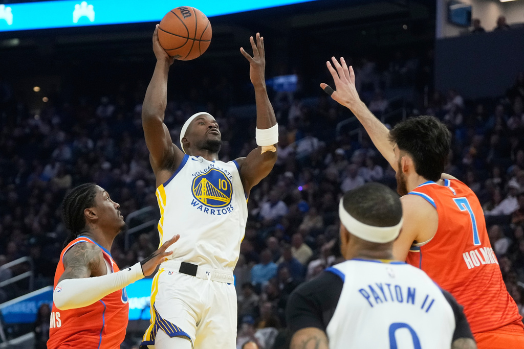 Golden State Warriors forward Jimmy Butler III (10) shoots against Oklahoma City Thunder guard Jalen Williams, left, and center Chet Holmgren (7) during the first half of an NBA basketball game in San Francisco, Tuesday, Dec. 2, 2025. (AP Photo/Jeff Chiu)