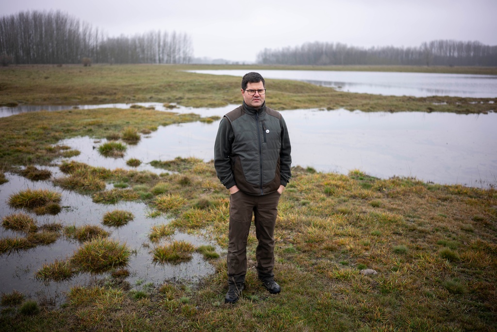 CORRECTS MONTH TO DECEMBER FROM JULY - Oszkár Nagyapáti, farmer and member of the volunteer water guardians group, poses for a photo with an artificial lake in Kiskunmajsa, Hungary, Dec. 12, 2025. (AP Photo/Denes Erdos)