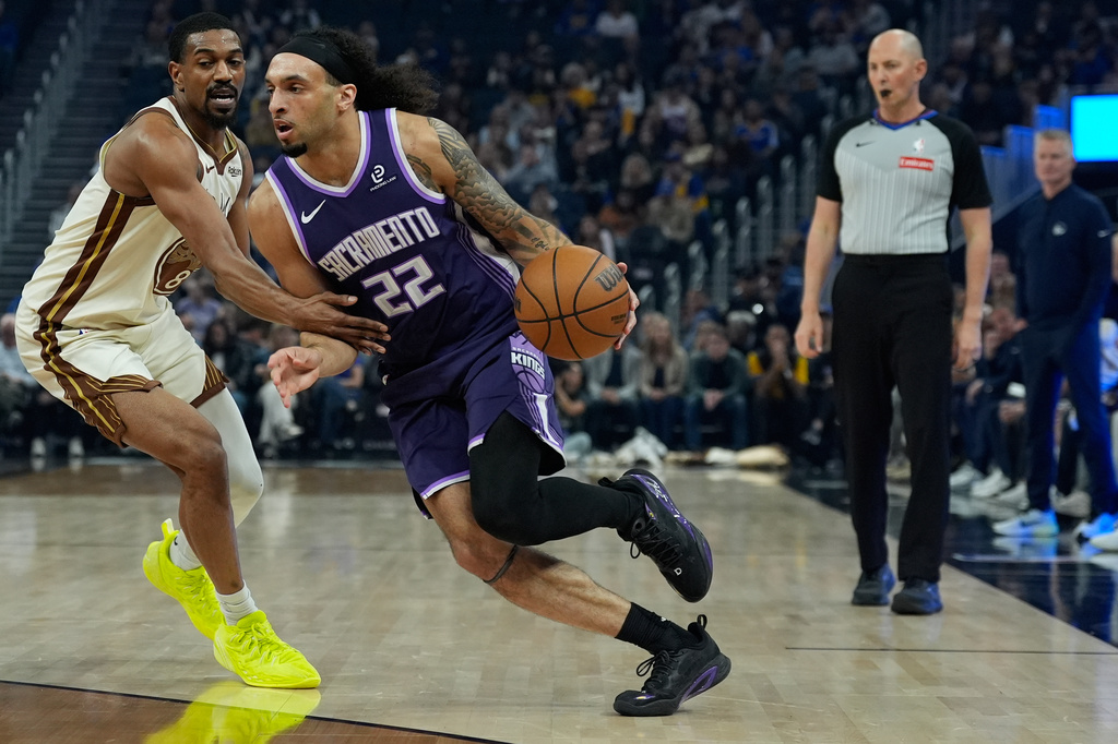 Sacramento Kings guard Devin Carter (22) moves the ball while defended by Golden State Warriors guard De'Anthony Melton during the first half of an NBA basketball game, Tuesday, April 7, 2026, in San Francisco. (AP Photo/Godofredo A. Vásquez)