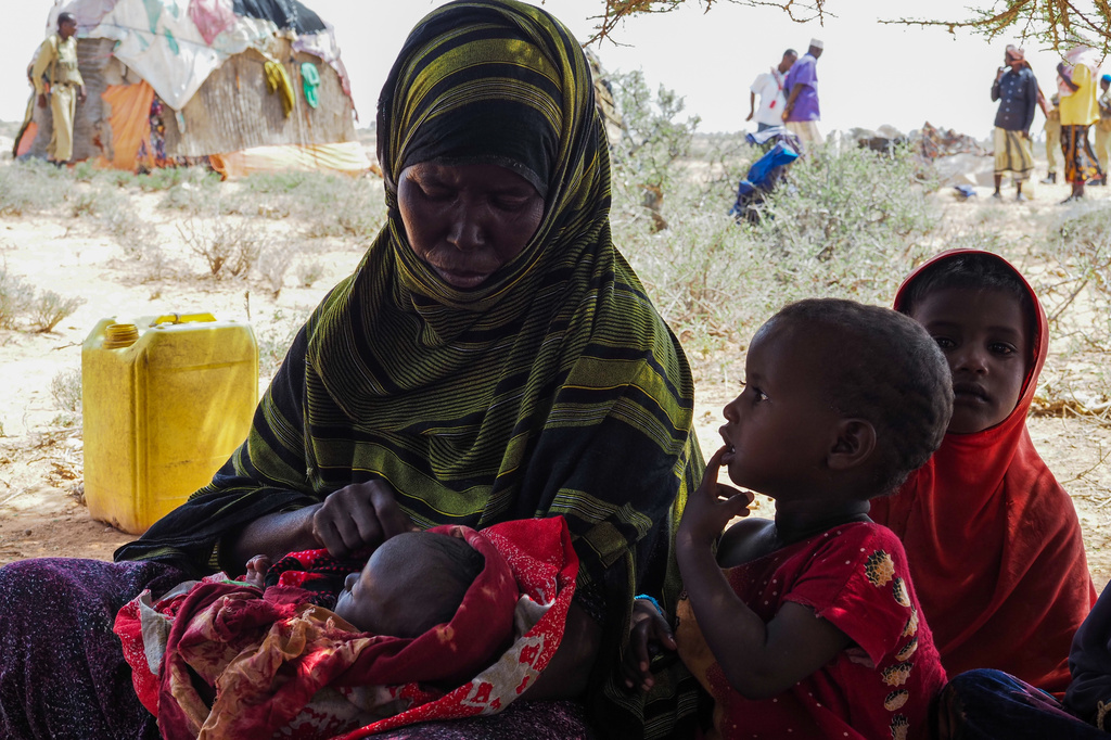 Abdi Ahmed Farah's wife, Absheera Ali, sits with her children outside their home in Usgure, Puntland, Somalia, Wednesday, April 15, 2026. (AP Photo/Jack Denton)