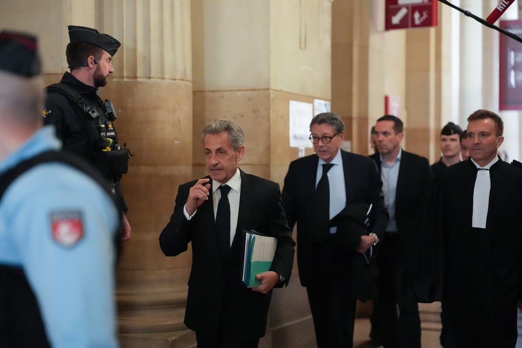 Former French President Nicolas Sarkozy, center left, arrives at the appeals courthouse in Paris, France, Monday, March 16, 2026, for his trial over alleged illegal financing of his 2007 presidential campaign by the government of late Libyan leader Moammar Gadhafi. (AP Photo/Thibault Camus)