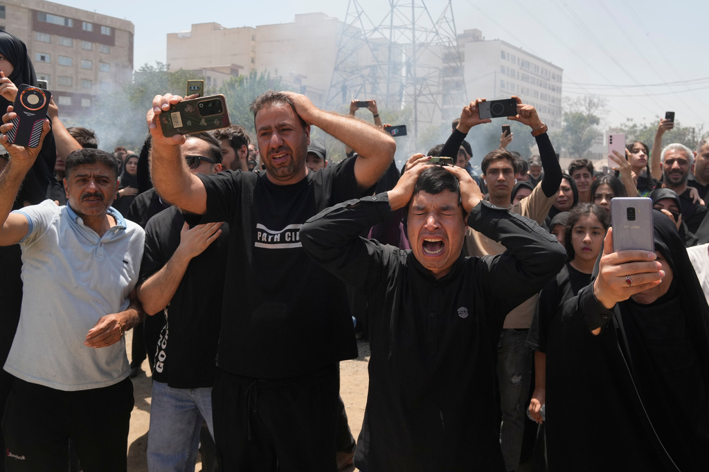 People mourn as they film the re-enactment of the battle of Karbala in A.D. 680 in present-day Iraq, in which Imam Hussein, a grandson of the Prophet Muhammad, one of Shiite Islam's most beloved saints, and his family and companions were killed after refusing to pledge allegiance to the Umayyad caliphate, in Tehran, Iran, Thursday, June 25, 2026, in the holy day of Ashoura which commemorates their martyrdom. (AP Photo/Vahid Salemi)