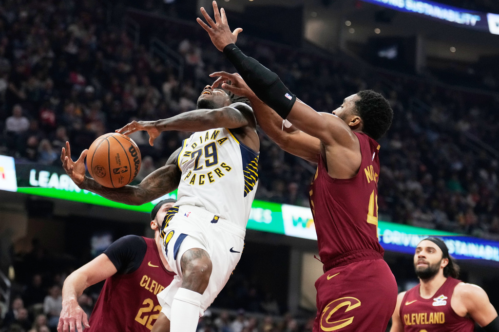 Indiana Pacers guard Quenton Jackson (29) is fouled by Cleveland Cavaliers guard Donovan Mitchell, right, in the first half of an NBA basketball game in Cleveland, Sunday, April 5, 2026. (AP Photo/Sue Ogrocki)