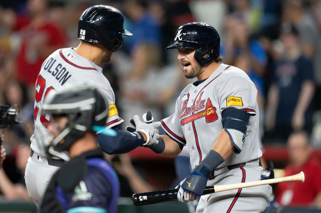 Atlanta Braves third baseman Austin Riley (27) celebrates a home run by Atlanta Braves first baseman Matt Olson (28) during the ninth inning of a baseball game against the Arizona Diamondbacks, Friday, April 3, 2026, in Phoenix. (AP Photo/Rebecca Noble)
