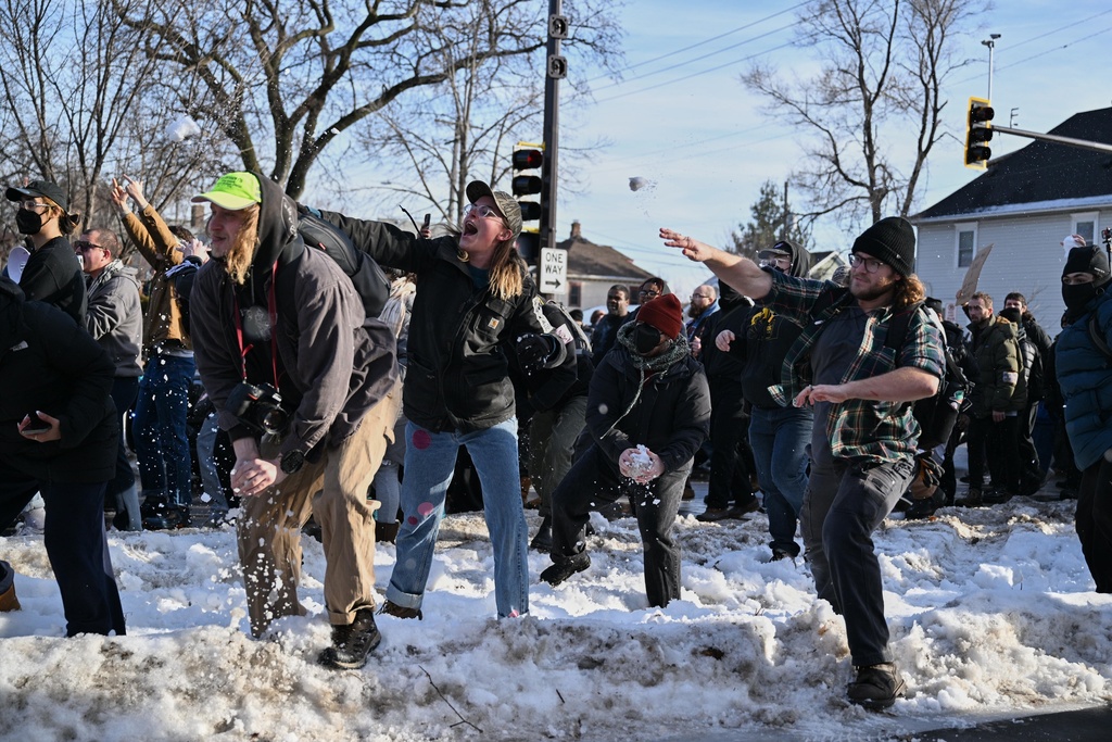 People protest as law enforcement officers attend to the scene of the shooting involving federal law enforcement agents, Wednesday, Jan. 7, 2026, in Minneapolis. (AP Photo/Tom Baker)