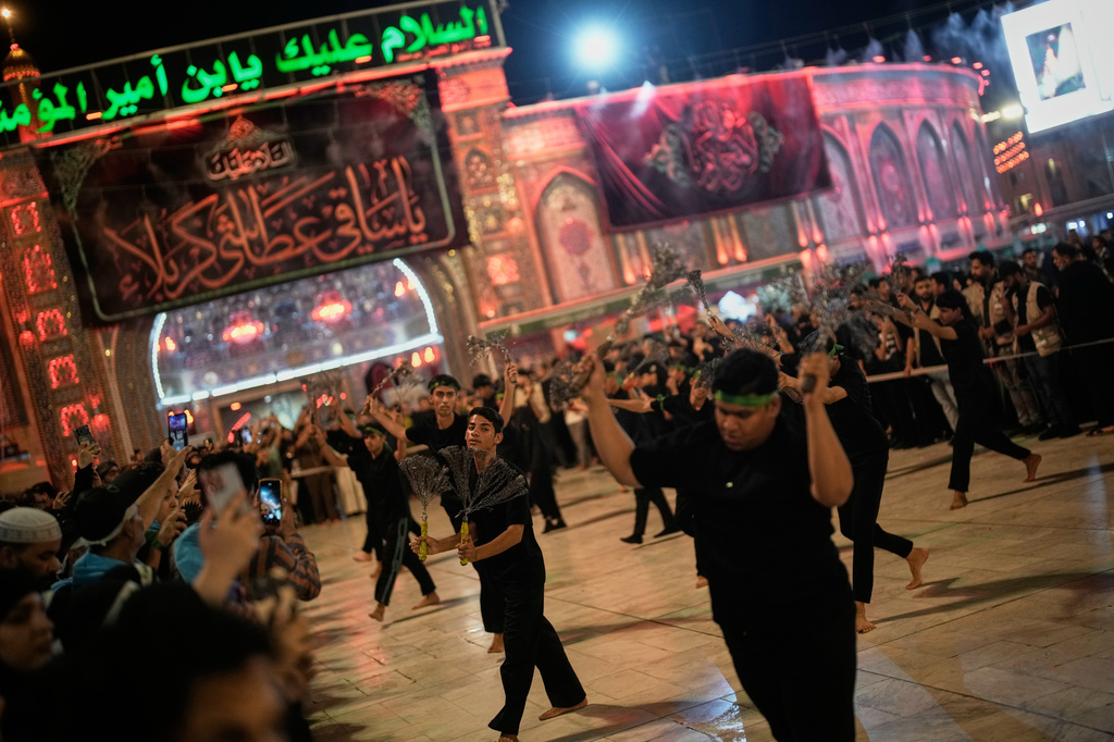 Shiite mourners perform ritual self-flagellation with chains outside the Imam Hussein Shrine on the eve of funeral ceremonies for the late Iranian Supreme Leader Ayatollah Ali Khamenei in Karbala, Iraq, Tuesday, July 7, 2026. (AP Photo/Khalil Hamra)