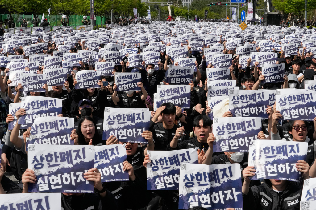Members of the Samsung Electronics labor union hold up their cards during a rally demanding higher bonuses at its computer chip complex in Pyeongtaek, South Korea, Thursday, April 23, 2026. The letters read "Remove the bonuses caps." (AP Photo/Ahn Young-joon)