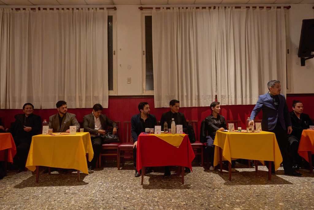Professional tango dancers known as "Taxi Dancers" take a break at the Che Che Tango Premium, where people can book guaranteed two‑hour dances with professional partners in Buenos Aires, Wednesday, Dec. 3, 2025. (AP Photo/Victor R. Caivano)