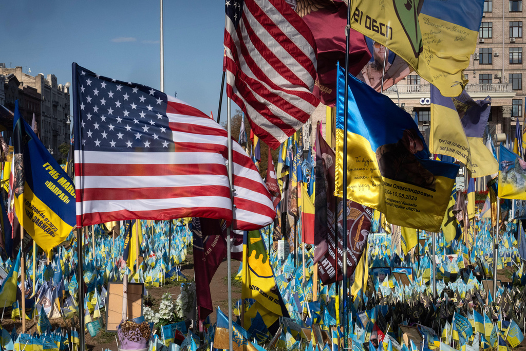 FILE - US and Ukrainian national flags wave to commemorate American volunteers, who were killed in battles with Russian troops defending Ukraine, their names are on flags, at the improvised war memorial in Independence square in Kyiv, Ukraine, Sept. 27, 2024. (AP Photo/Efrem Lukatsky, File)