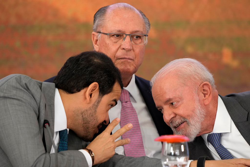 FILE - Brazil's Attorney General Jorge Messias, left, leans over to speak with President Luiz Inacio Lula da Silva at a signing ceremony of a compensation agreement for damages caused by the 2015 collapse of the Mariana Dam owned by the mining company Samarco, a joint venture of Vale and BHP, at the Planalto Presidential Palace, in Brasilia, Brazil, Oct. 25, 2024. Pictured center is Vice President Geraldo Alckmin. (AP Photo/Eraldo Peres)