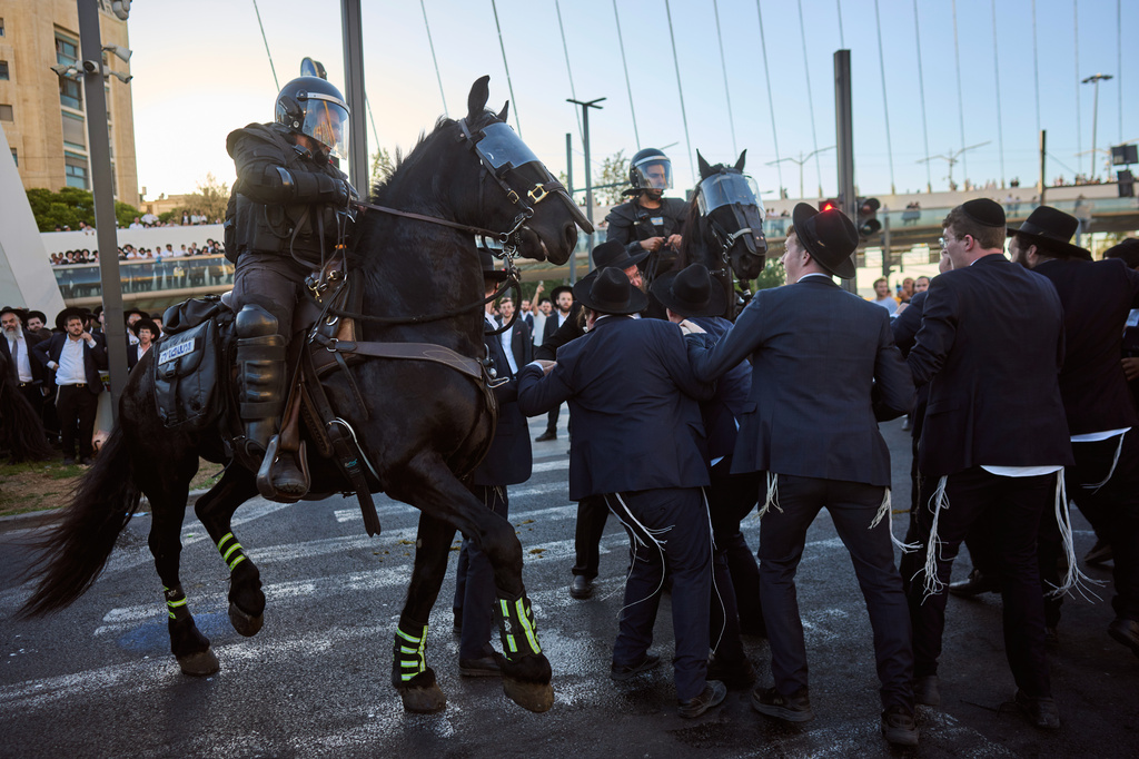 Israeli mounted police disperse Ultra-Orthodox Jews blocking a road during a protest against the army draft in Jerusalem, Monday, June 1, 2026. (AP Photo/Ohad Zwigenberg)