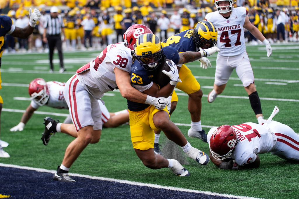 Michigan running back Jordan Marshall (23) scores a one-yard touchdown as Oklahoma linebacker Owen Heinecke (38) defends in the second half of an NCAA college football game Saturday, Sept. 12, 2026, in Ann Arbor, Mich. (AP Photo/Paul Sancya)