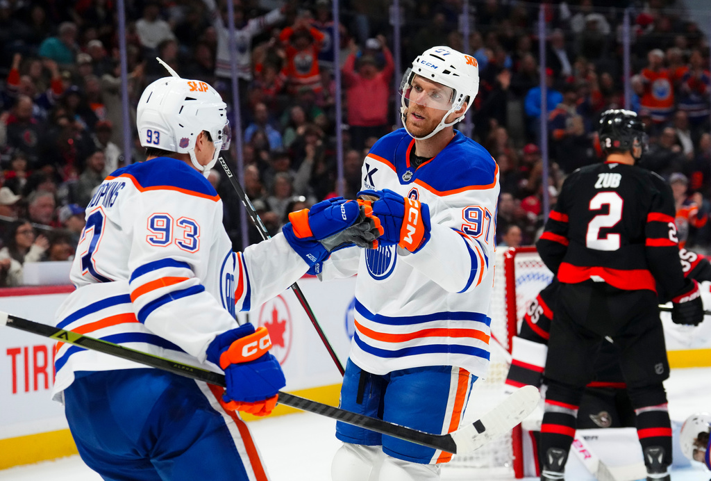 Edmonton Oilers' Connor McDavid (97) celebrates his goal with teammate Ryan Nugent-Hopkins (93) during first period NHL hockey action against the Ottawa Senators, in Ottawa on Tuesday, Oct. 21, 2025. (Sean Kilpatrick/The Canadian Press via AP)