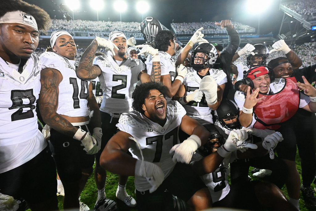 Oregon players celebrate their second overtime win over Penn State during their NCAA college football game, Saturday, Sept. 27, 2025, in State College, Pa. (AP Photo/Barry Reeger)